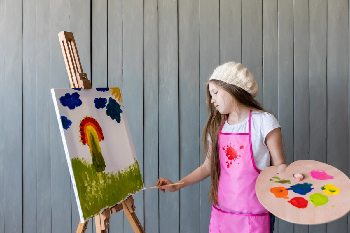 portrait-girl-holding-wooden-palette-hand-painting-easel-with-brush